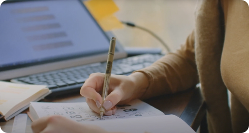 Person Writing in a Notebook